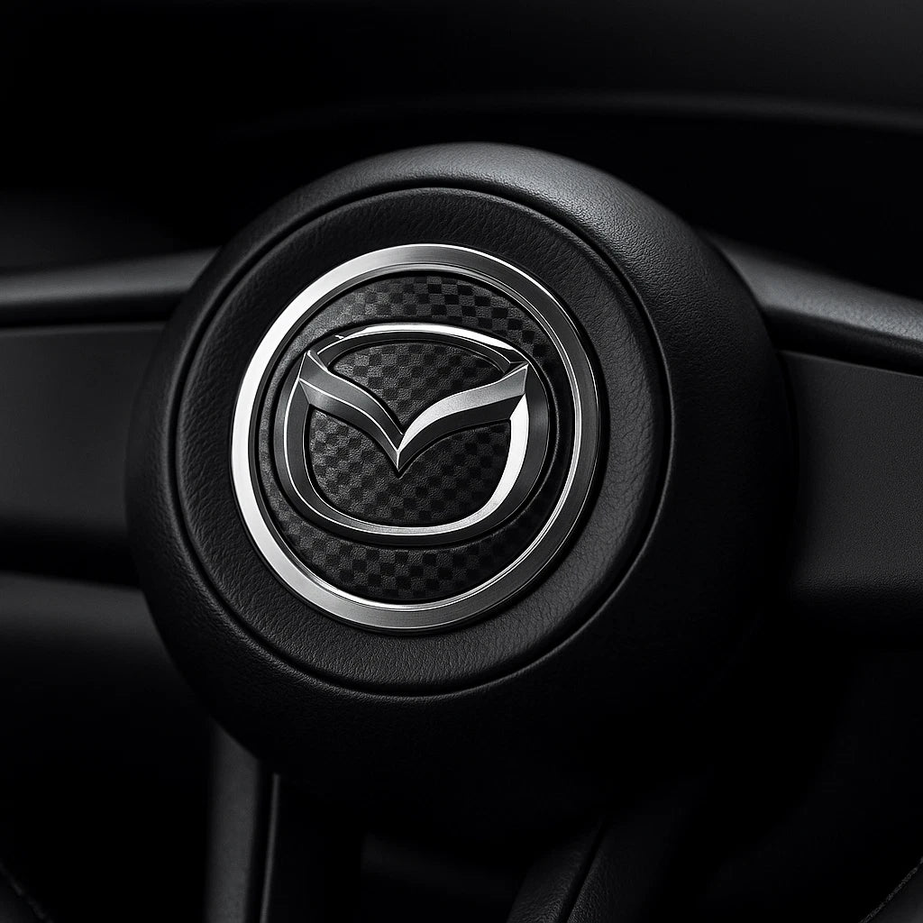 Chrome Mazda emblem installed on a steering wheel